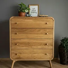 Two-man removal team carefully carrying a chest of drawers downstairs